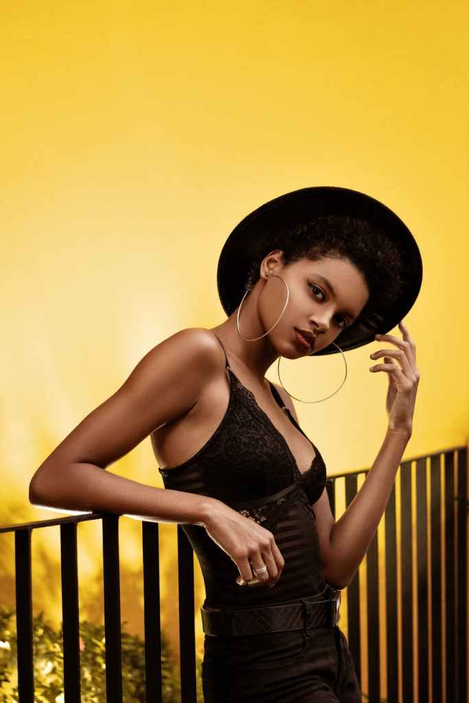 model posing in black outfit with black hat